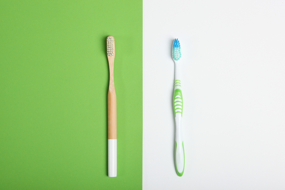 彩色背景图上的天然竹子牙刷和塑料